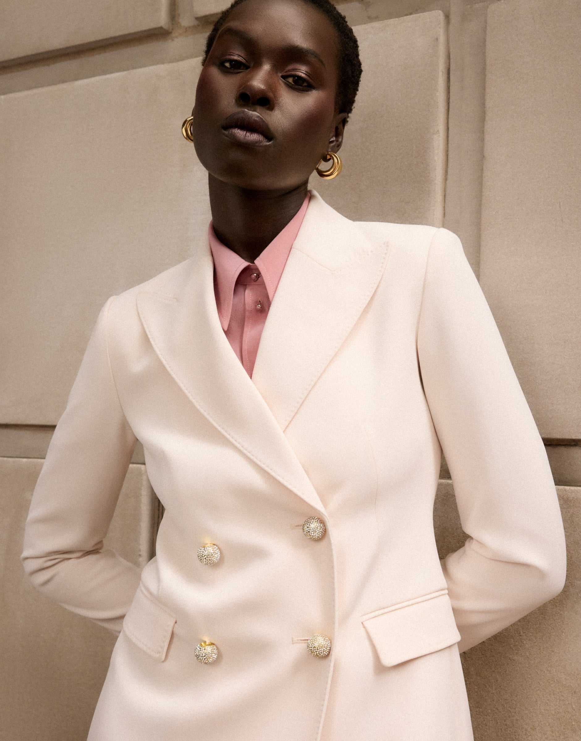 Women wearing St John Knits collection white jacket with pink blouse.