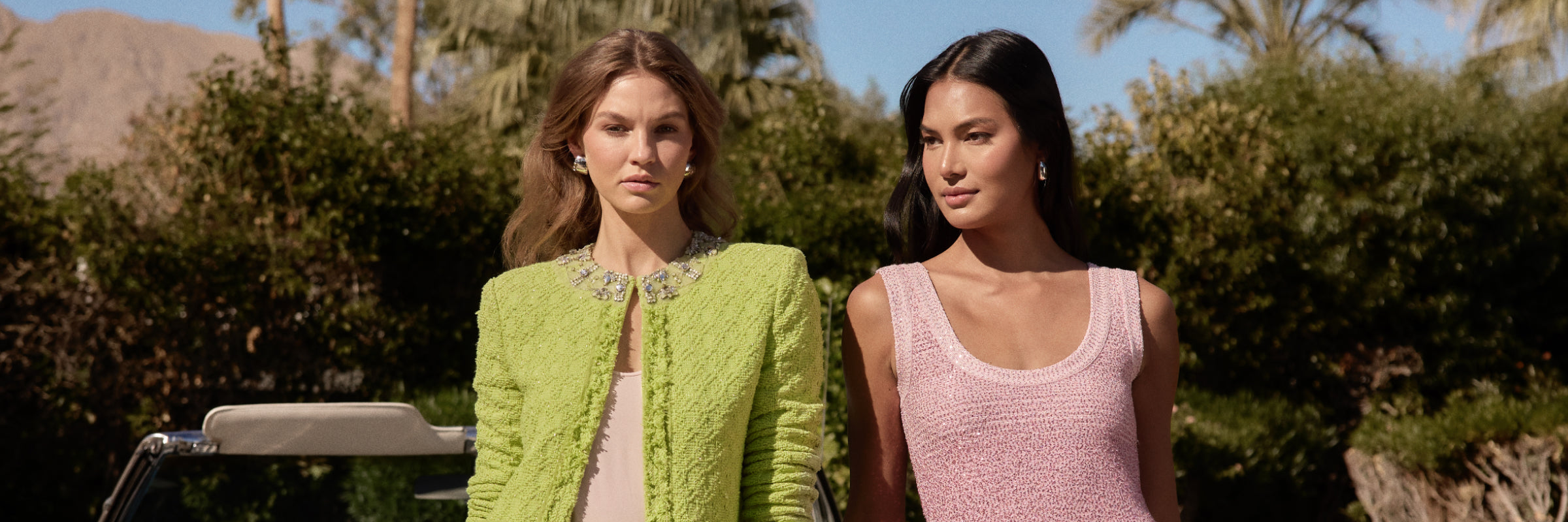 women wearing St John Knits green jacket and matching skirt with friend wearing pink knit dress